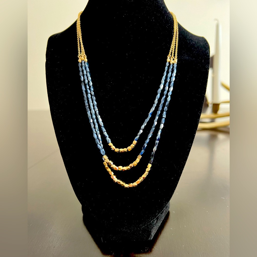 Three strand dark blue and gold beaded necklace.